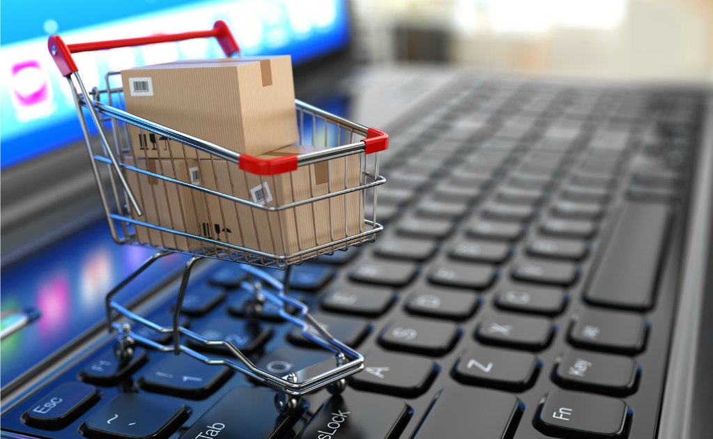 E-commerce. Shopping cart with cardboard boxes on laptop. 3d